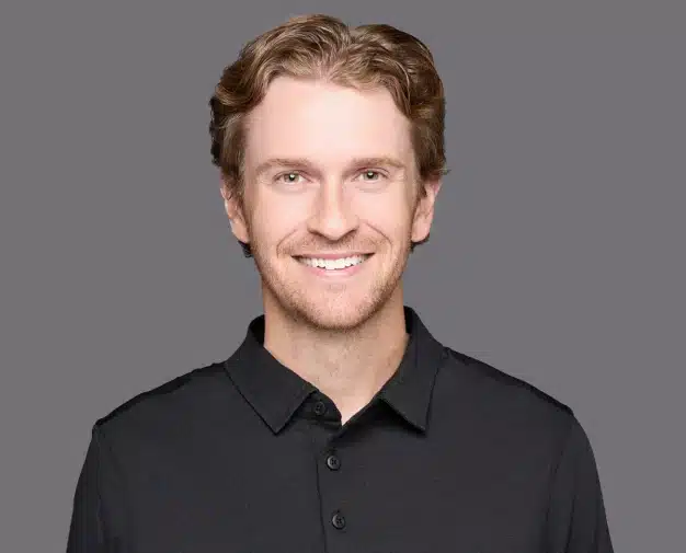 Dr. Brock Wilde smiling in a professional headshot at Aurora Dental Group in Lacombe AB