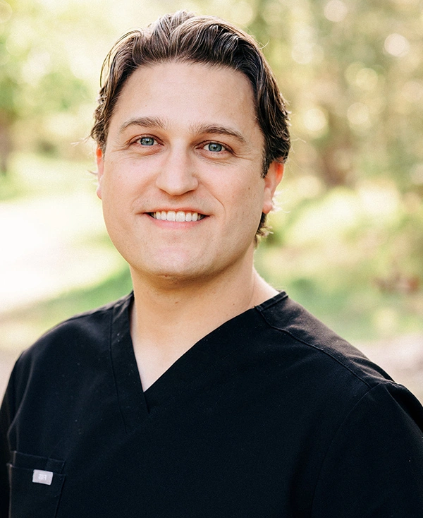 Dr. Blake Anderson, dentist at Grants Pass dental practice, smiling outdoors.