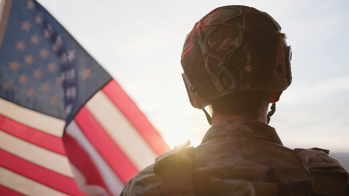 Soldier in military uniform saluting American flag at Grants Pass, OR dental office.