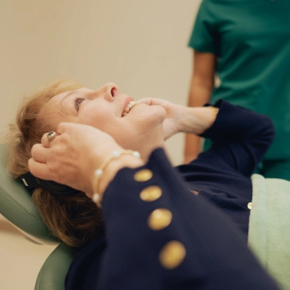 Dentist performing tooth extraction procedure on patient in dental chair.