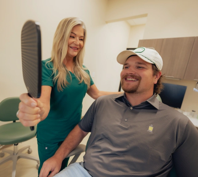 Smiling dental patient and female dentist in treatment room at Newnan dental practice.