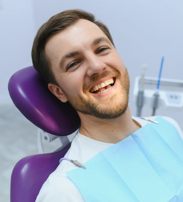 Happy patient smiling in dental chair after deep cleaning at Burbank dental office.
