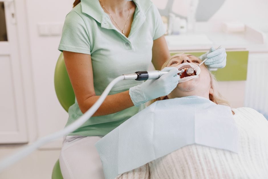 Dentist performing an oral examination on a patient in a clinic setting.