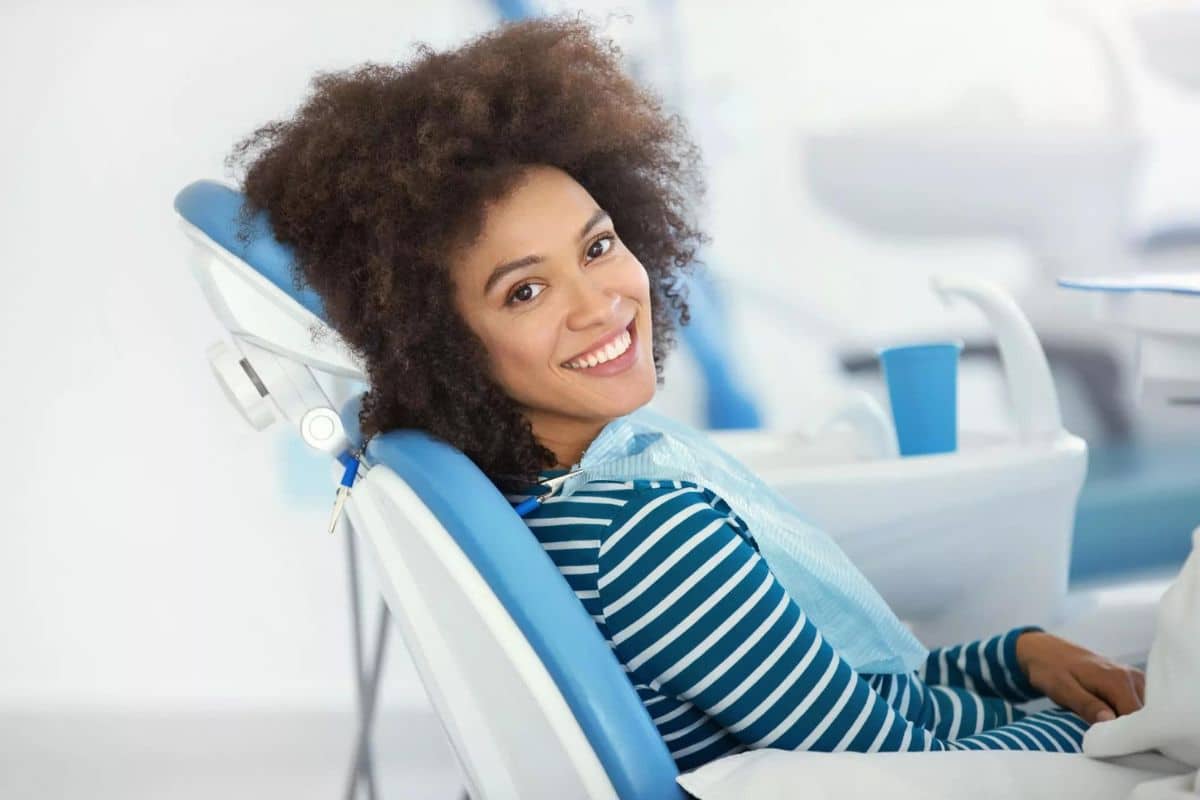 Sedation Making Your Dental Procedure as Comfortable as Possible Woman patient smiling in dental chair during examination at modern dental office