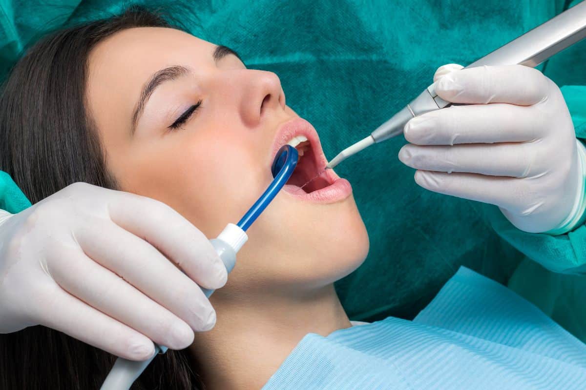 Dentist examining patient's mouth with tools during dental checkup in clinical setting