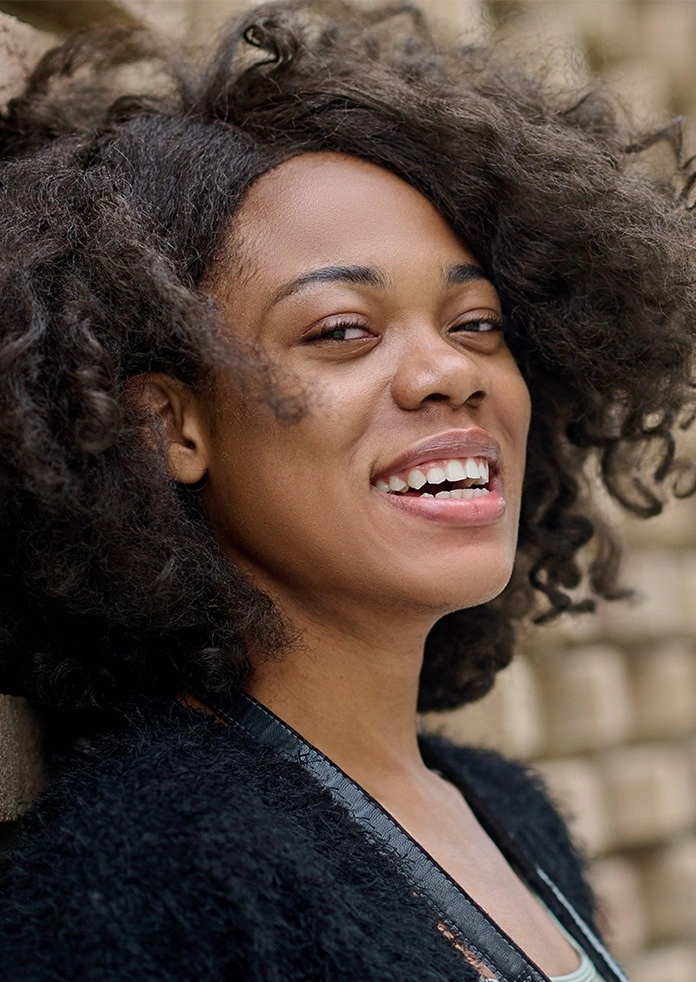 a woman smiling confidently with white teeth, showcasing results of a smile makeover