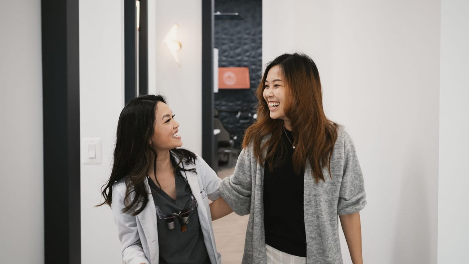 our dentists walking together in a hallway, appearing friendly and engaged in conversation