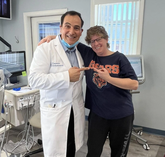 Dr. Cosmo Haralambidis standing with an old patient in the orthodontic treatment room at Cranston Orthodontics