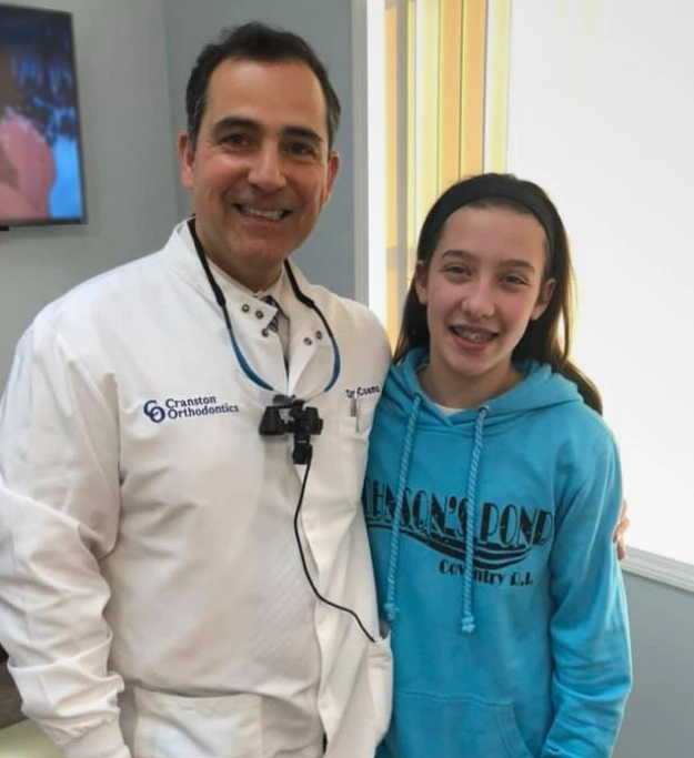 Dr. Cosmo Haralambidis posing with a patient at Cranston Orthodontics