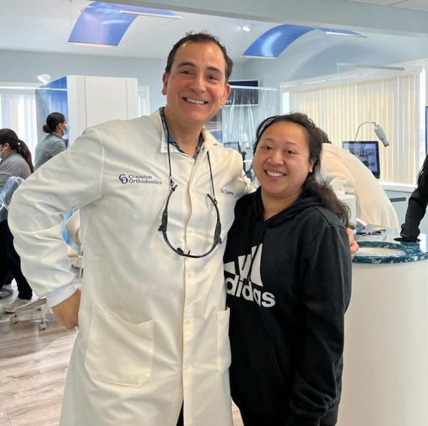 Dr. Cosmo Haralambidis standing with a patient at Cranston Orthodontics