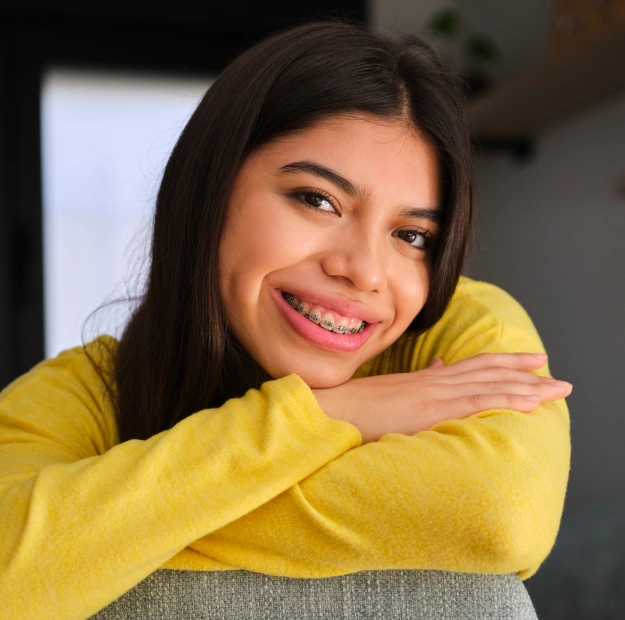 Smiling patient resting her chin on folded arms