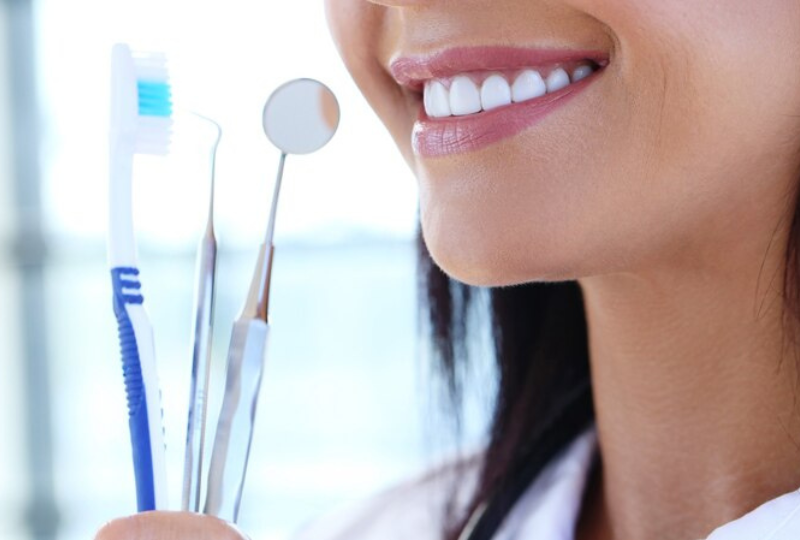 Dental mirror and explorer tools resting near a patient's teeth