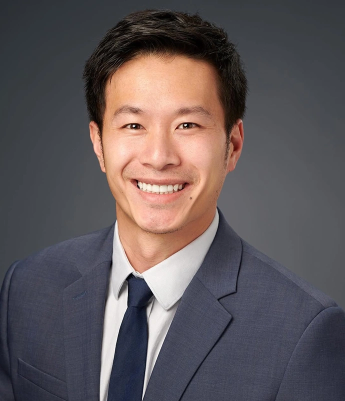 Portrait of Dr. David Wong smiling in a suit against a neutral background