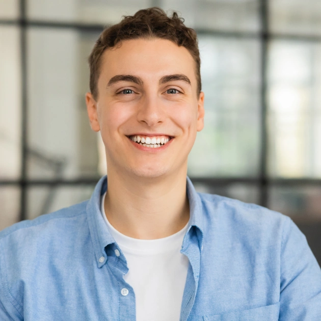 Portrait of a smiling boy in a blue shirt indoors