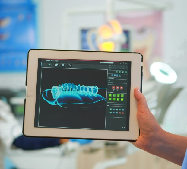 Dental professional holding a tablet displaying a digital dental X ray