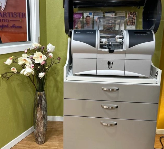 Modern dental office with a milling machine and floral arrangement on a counter