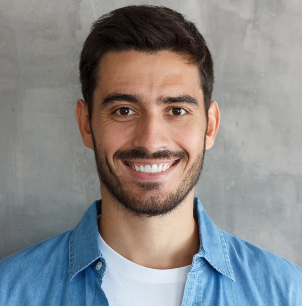 Portrait of a smiling man in a blue shirt against a neutral background