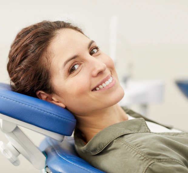 Young woman smiling while seated in a dental chair during an appointment