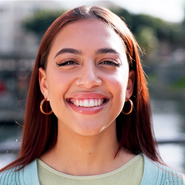 Portrait of a young woman with red hair smiling warmly