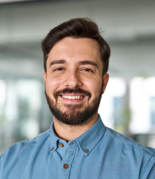 Portrait of a smiling young man in a casual shirt in an outdoor setting