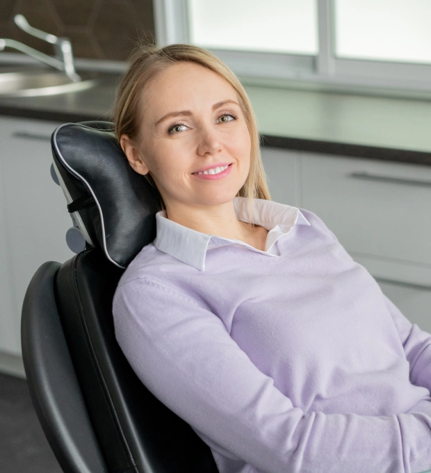 Young female patient smiling while seated in a dental chair