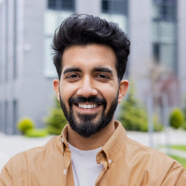 Portrait of a smiling man with a beard in an urban outdoor setting