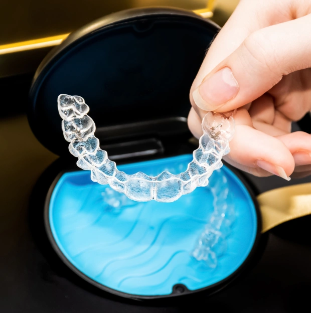 Clear aligner tray displayed in an open blue storage case