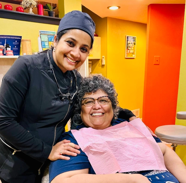 Dr. Radhika Srikrishnan Iyer smiling with a happy patient in a dental chair at Dental Artistry Irving