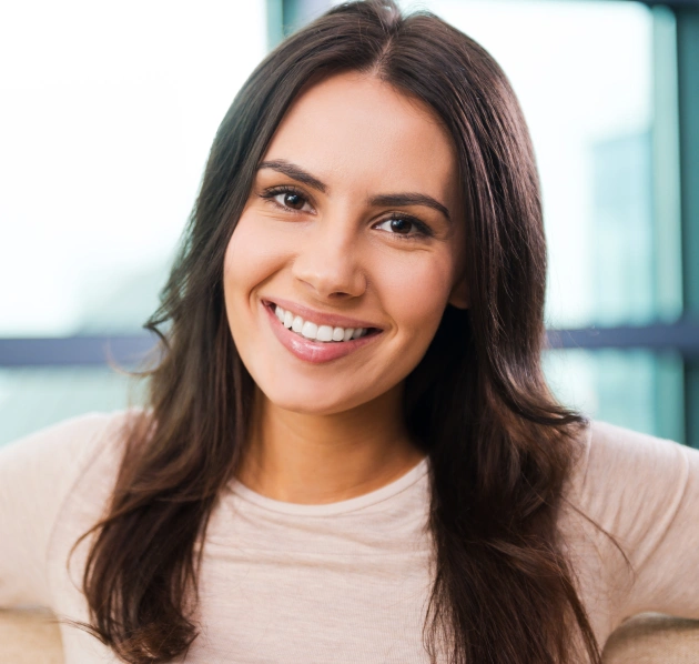 Portrait of a young woman with long dark hair smiling warmly