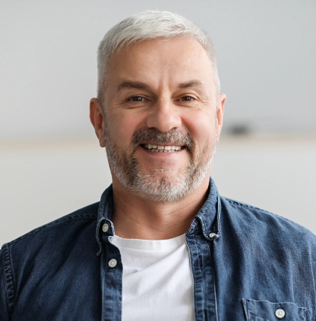 Portrait of a middle aged man with grey hair smiling warmly
