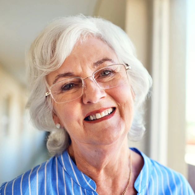 Portrait of an older woman with short white hair smiling warmly