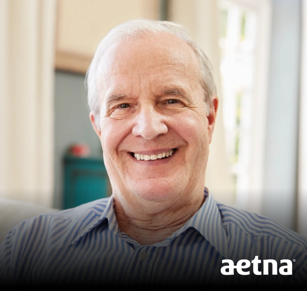 Portrait of a smiling older man in a casual setting with an Aetna dental logo overlay