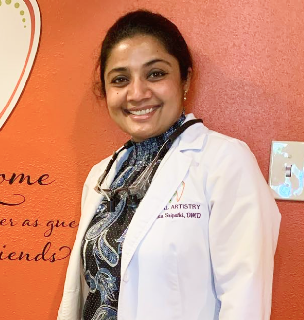 Dr. Radhika Srikrishnan Iyer smiling in her white coat at Dental Artistry Irving