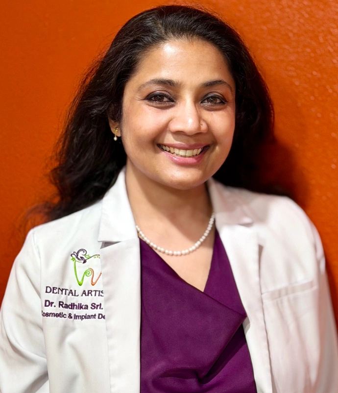 Dr. Radhika Srikrishnan Iyer smiling in her white coat at Dental Artistry Irving