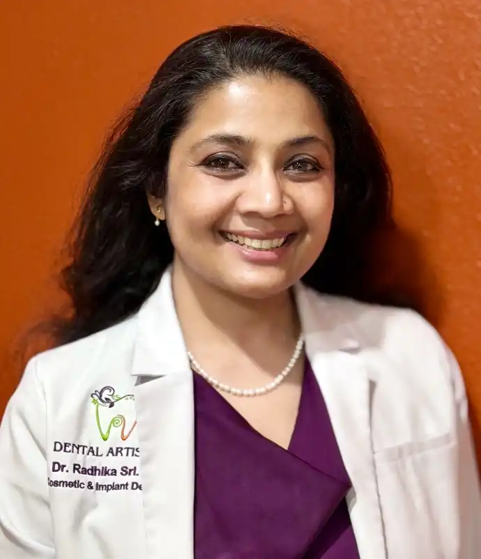 Dr. Radhika Srikrishnan Iyer smiling in her white coat at Dental Artistry Irving