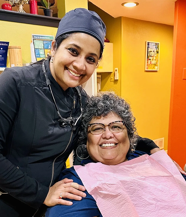 Dr. Radhika Srikrishnan Iyer smiling with a happy patient in a dental chair at Dental Artistry Irving