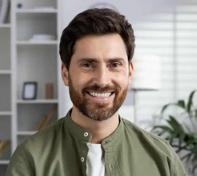 Portrait of a smiling man with a beard in a casual green shirt