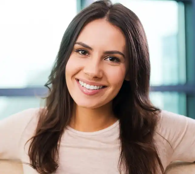 Portrait of a young woman with long dark hair smiling warmly