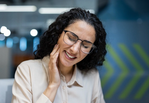Woman holding her jaw in pain due to TMJ disorder seeking treatment at The Dentist Place of Clearwater in Clearwater, FL