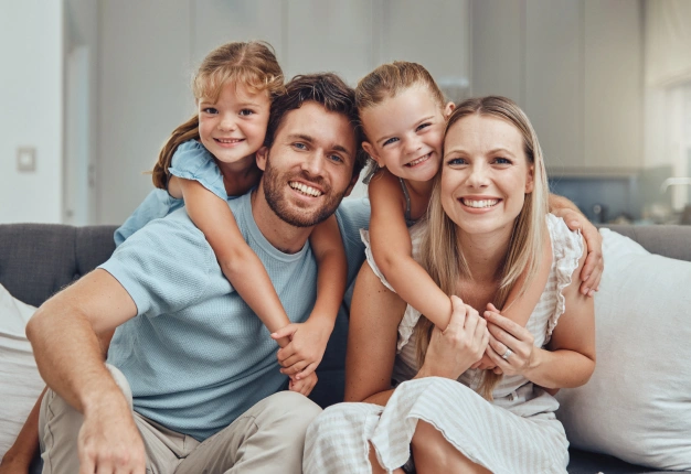 Happy family with two young children smiling together representing family dentistry at The Dentist Place of Clearwater in Clearwater, FL