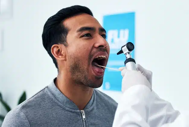 Dentist performing an oral cancer screening examination on a male patient at The Dentist Place of Clearwater in Clearwater, FL