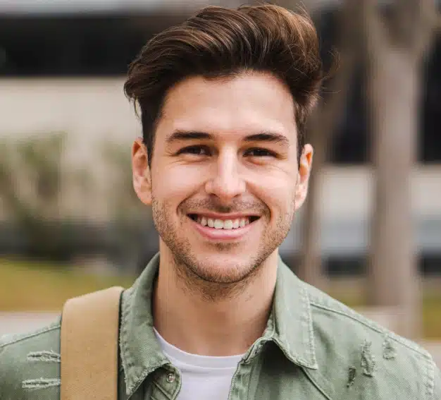 Young man smiling confidently after restorative dentistry treatment at The Dentist Place of Clearwater in Clearwater, FL