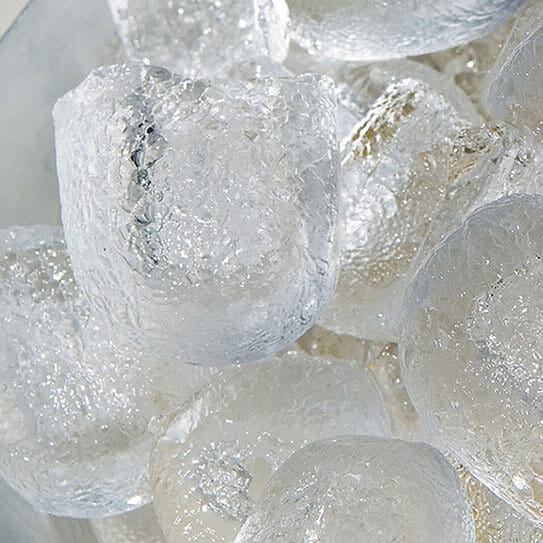 Close-up of ice cubes in clear liquid, showing frozen water crystals and condensation.