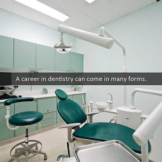 Modern dental operatory with teal chairs, overhead lights, and cabinets in professional clinic setting.