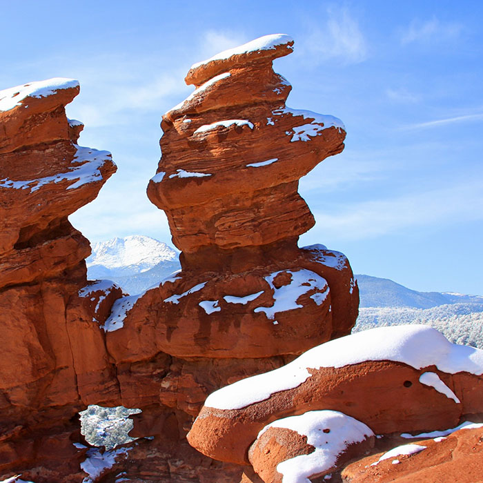 fluoride-2021_700.jpg Red rock formations with snow patches under blue sky, desert landscape.
