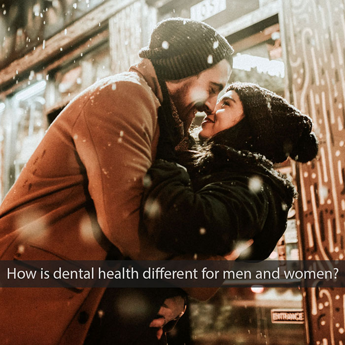 men-vs-women-dental-2022_700.jpg Couple kissing outdoors in winter setting with snow falling around them.
