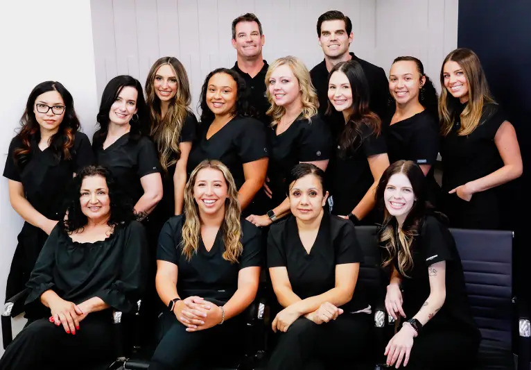 dentistryofoldtownscottsdale team mobile Professional dental team in black scrubs posing together in office setting.