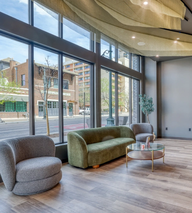 A bright waiting area with green chairs and large windows at Denver Orthodontics and Dental Lounge in Denver CO