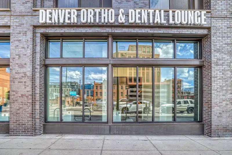 The exterior storefront of Denver Orthodontics and Dental Lounge showing the practice sign at 1890 Market Street Denver CO