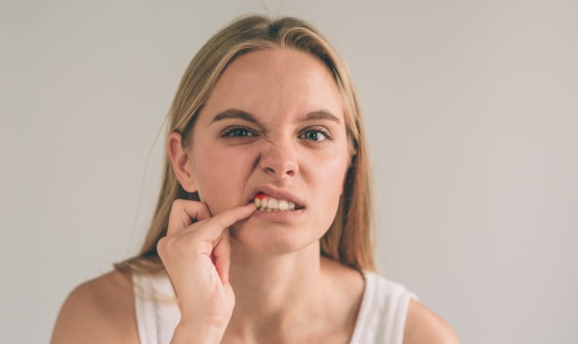 What causes a black spot on a human gum near a tooth?